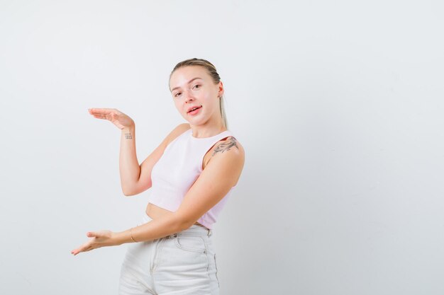 Blonde girl is explaining a big box on white background