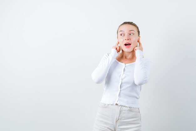 Blonde girl is listening to music on white background