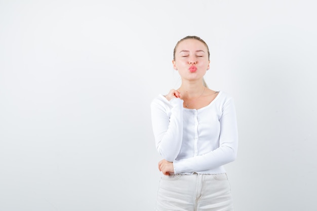 Blonde girl is sending kiss to her lovers on white background