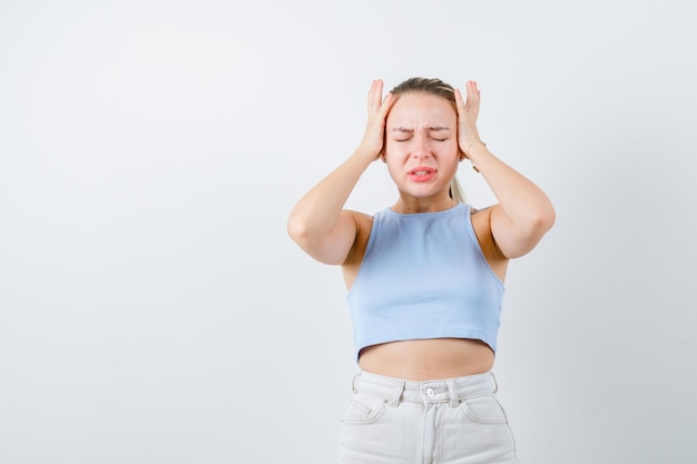 blonde girl is showing her headache on white background