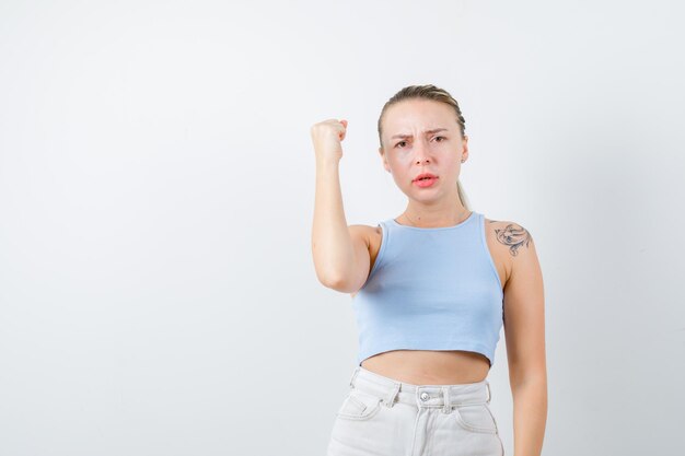 blonde girl is showing that she is so strongly on white background