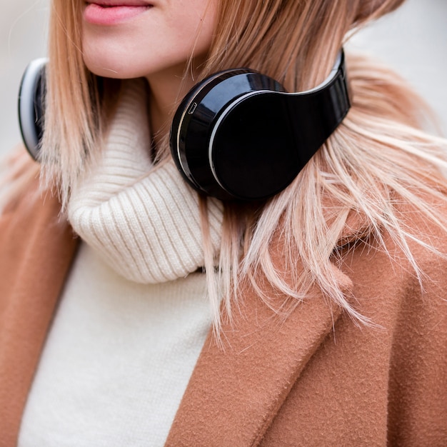 Blonde girl listening to music on headphones close-up