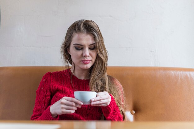 ブロンドの女の子は、コーヒーの彼女のカップを見て