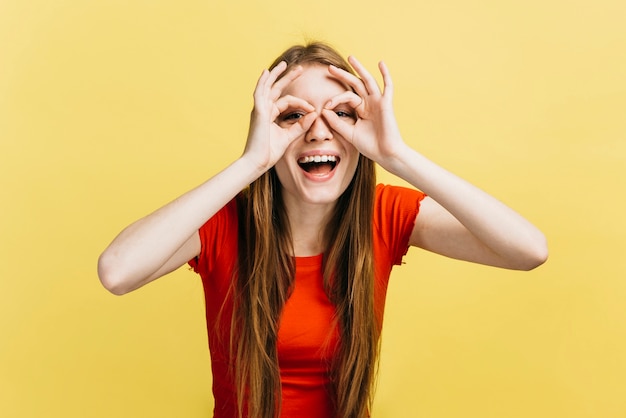 Free photo blonde girl making glasses with her fingers