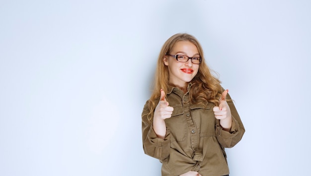 Blonde girl noticing and pointing at the person ahead.