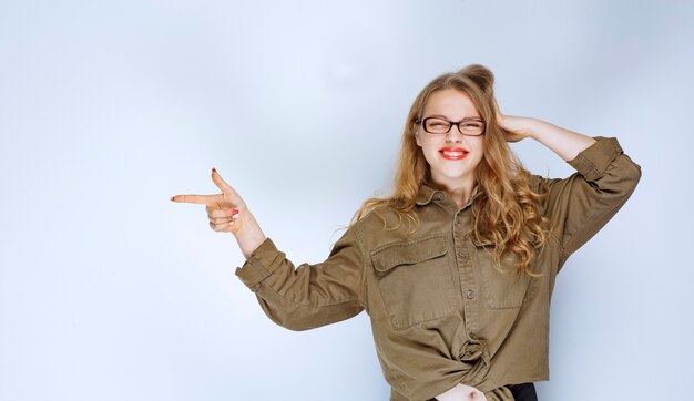 Blonde girl pointing at someone on the left.