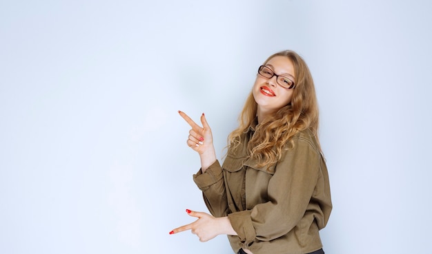 Blonde girl pointing at someone on the left.