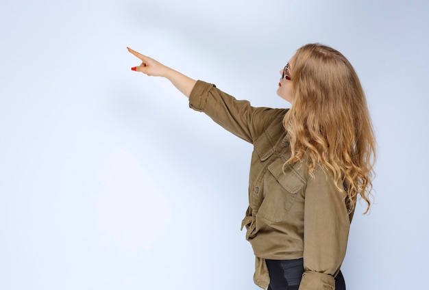 Blonde girl pointing at someone on the left.