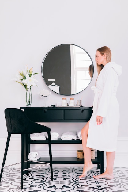 Blonde girl posing in the bathroom with bath robe