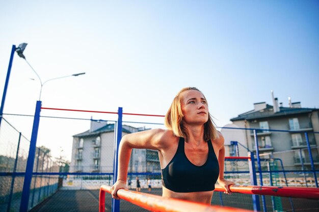 Blonde girl pulling up on bars