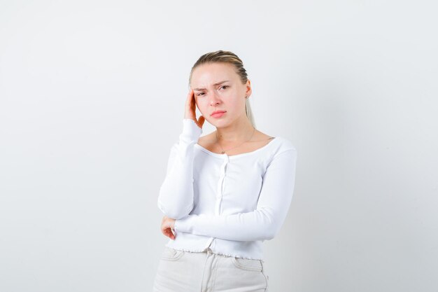 Blonde girl seems thoughtfully on white background