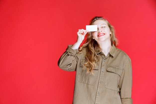 Free photo blonde girl showing her business card and networking.