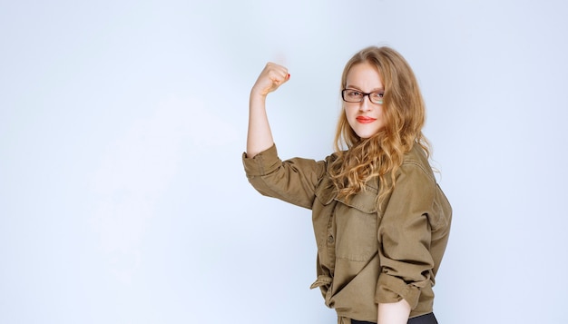 Blonde girl showing her fist and feeling powerful.