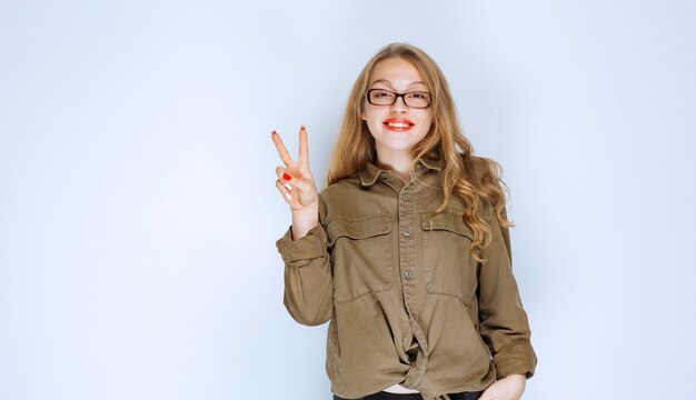 Blonde girl showing peace and friendship hand sign.