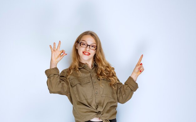 Blonde girl showing positive hand sign.