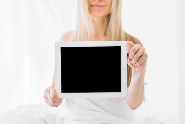 Free photo blonde girl showing tablet