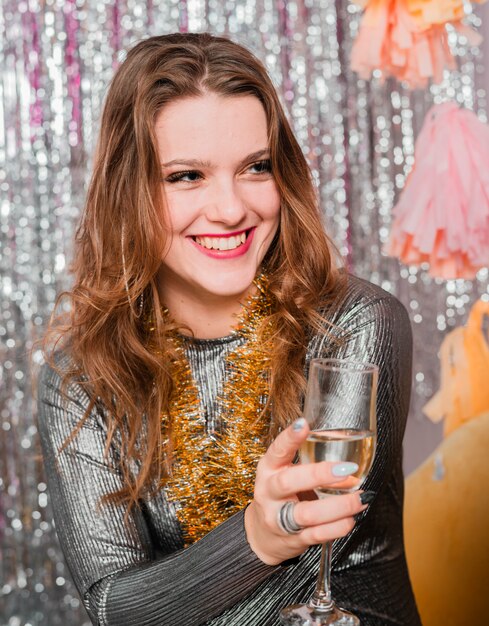 Блондинка улыбается с шампанским на вечеринке в новом году