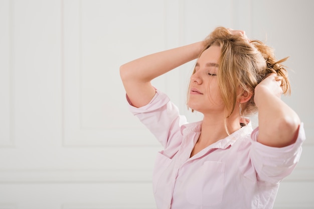 Free photo blonde girl taking care of her hair