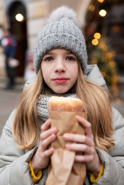Foto gratuita ragazza bionda che assaggia un dolce durante le sue vacanze invernali