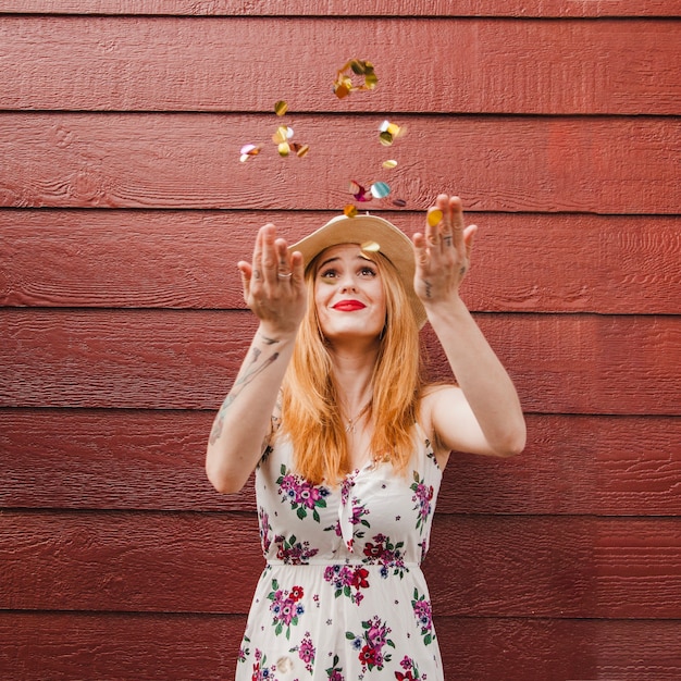 Free photo blonde girl throwing confetti