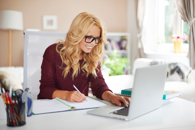 Blonde girl using laptop during studying at home