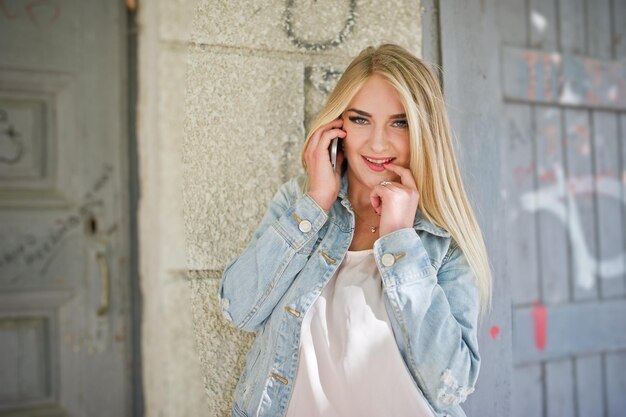 Blonde girl wear on jeans jacket posed at street