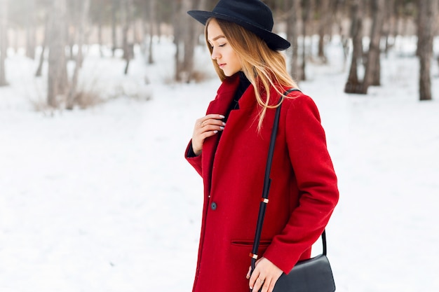 Блондинка в красном пальто на снежном поле