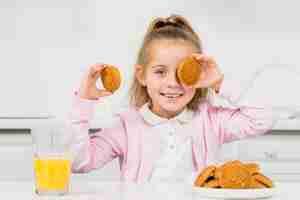 Free photo blonde girl with cookies and juice