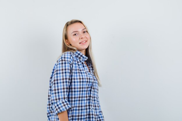 Blonde lady in casual shirt looking at camera and looking merry