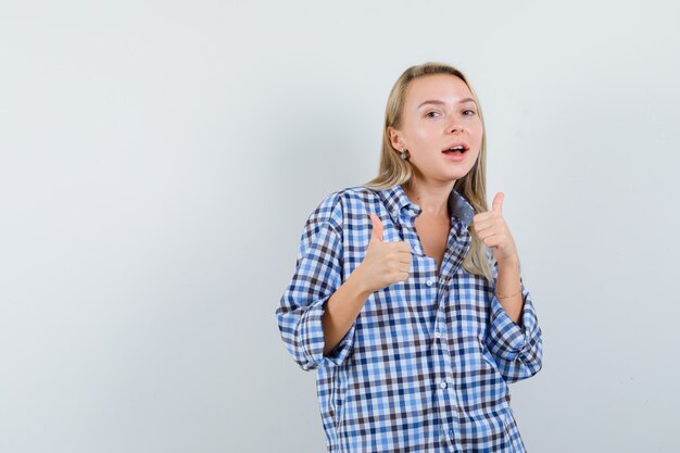 Blonde lady in casual shirt showing double thumbs up and looking happy