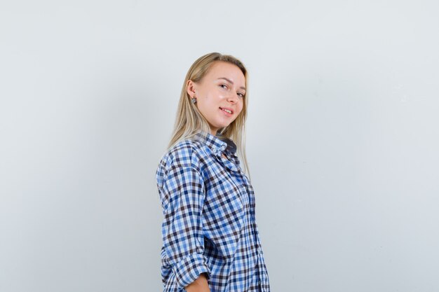 Blonde lady in checked shirt looking at camera and looking confident .