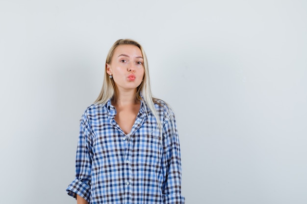 Free photo blonde lady in checked shirt pouting lips and looking attractive