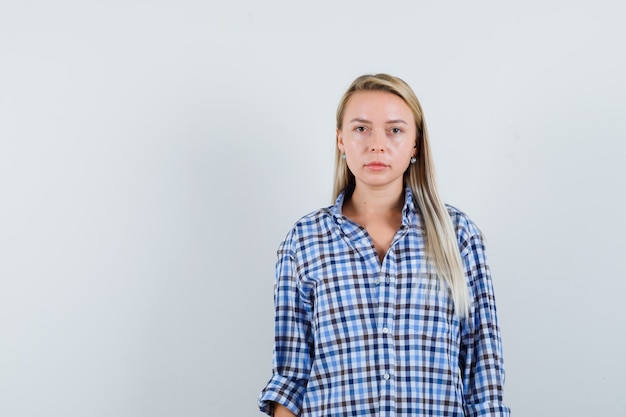 Blonde lady looking at camera in checked shirt and looking sensible