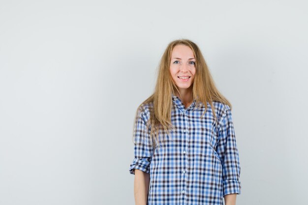 Blonde lady looking at camera in shirt and looking cheerful.