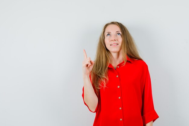 赤いシャツを着て、希望に満ちた金髪の女性、