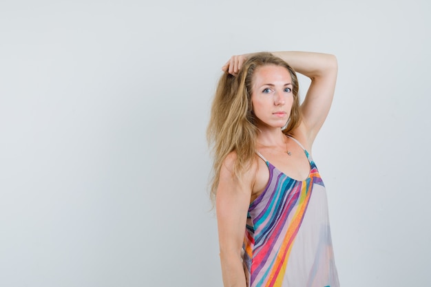 Blonde lady posing while holding strand in summer dress and looking cute 