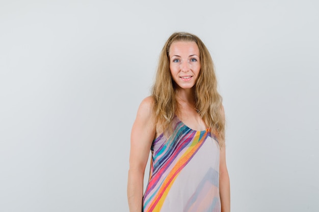 Blonde lady in summer dress looking at camera and looking optimistic 