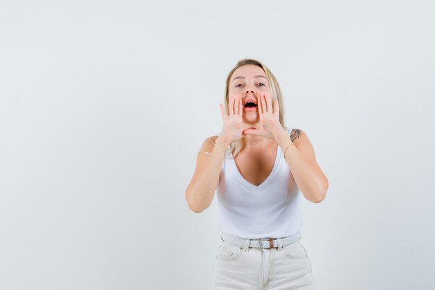 비밀을 말하거나 중항, 바지 전면보기에서 뭔가를 발표하는 금발 아가씨.