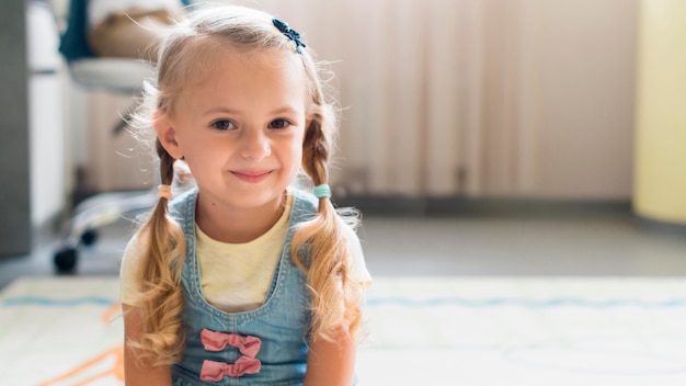 Foto gratuita bambina bionda che sorride con lo spazio della copia