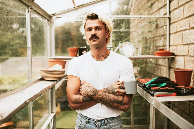 Blonde man his his greenhouse