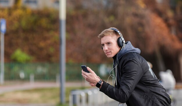 Blonde man listening to music outside