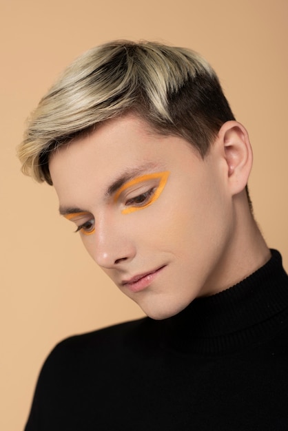 Blonde man wearing orange eyeliner