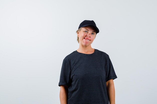 Blonde mature woman in a black t-shirt and a black cap