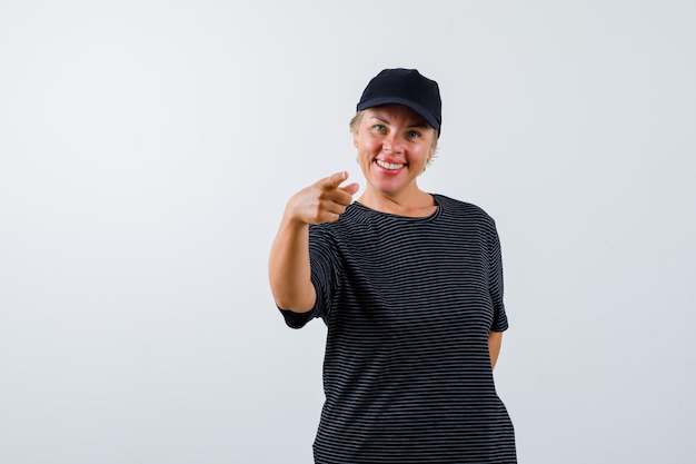 Blonde mature woman in a black t-shirt and a black cap