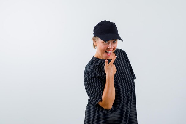 Blonde mature woman in a black t-shirt and a black cap