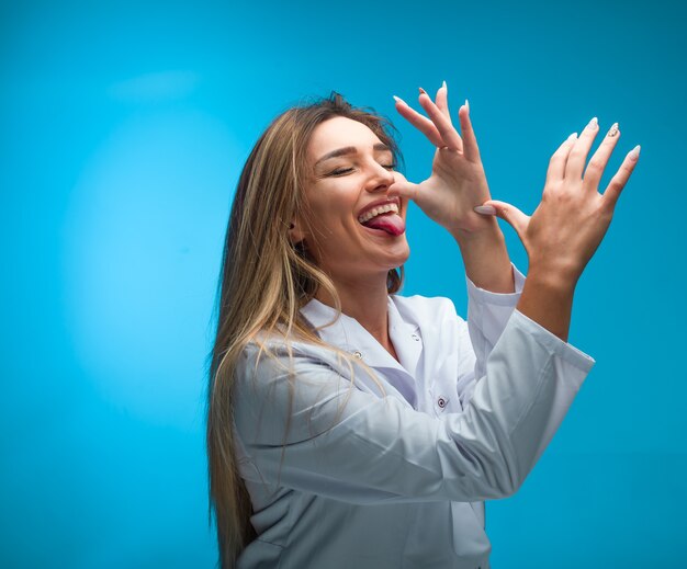 Blonde model in white shirt looks seductive and joking.