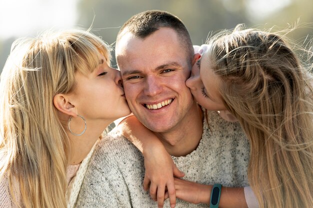 Blonde mother and lovely daughter kissing her father