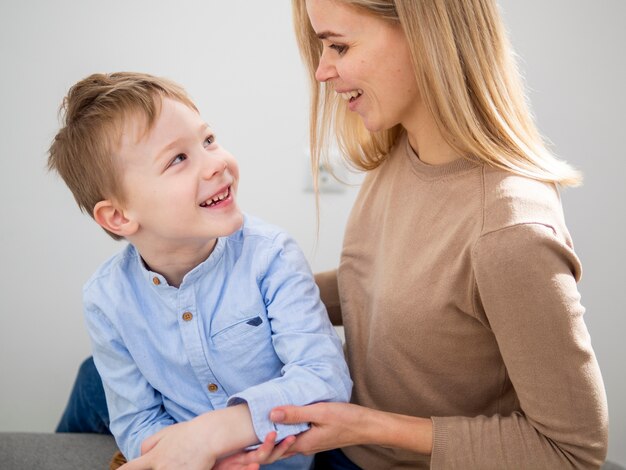 金髪の母親と若い男の子がお互いに笑みを浮かべて