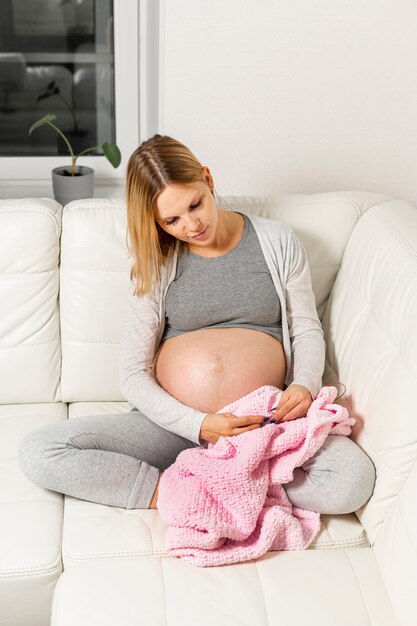 毛布を保持している金髪の妊娠中の女性