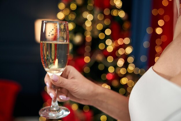 Blonde seductive woman holding glass of champagne cheering